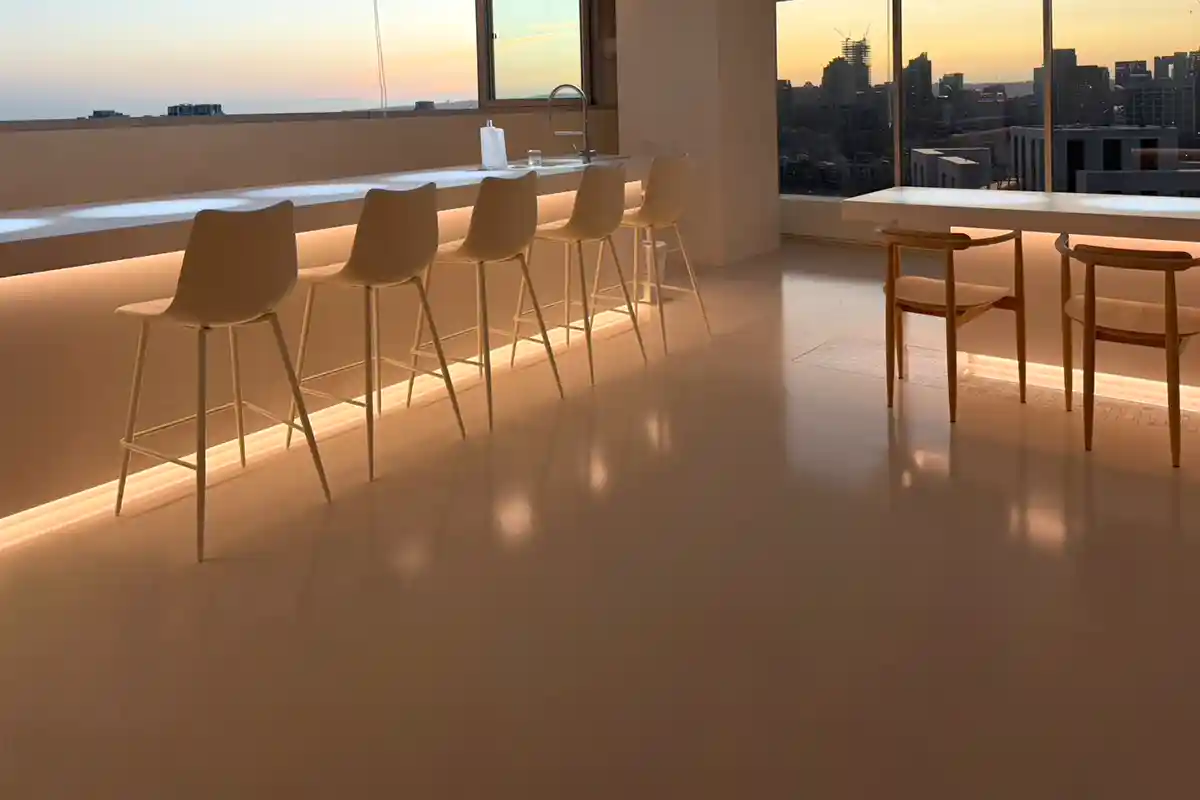 高樓層辦公空間的淺灰色高光澤地坪,映出落地窗與窗外城市景觀